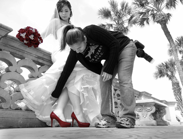 Show us your shoes. The official photographer adjusts the dress of Victoria Garcia to reveal her choice of footwear.
Artist Statement: I desaturated the entire photo then colored back in the shoes and the flowers to emphasize the color.
Photo by Mona Gallegos