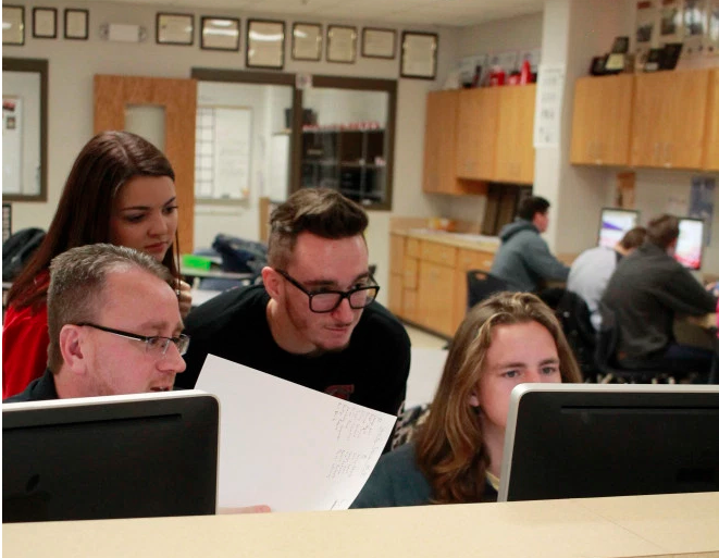 Leland Mallett, Legacy High School's Student Publications Adviser, works with yearbook students on a deadline.