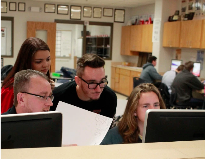 Leland Mallett, Legacy High Schools Student Publications Adviser, works with yearbook students on a deadline.